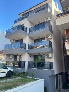 an apartment building with balconies and a car parked in front at Medoni Summer Hive in Sozopol +6 photos
