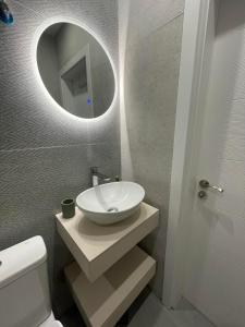 a bathroom with a white sink and a mirror at Medoni Summer Hive in Sozopol