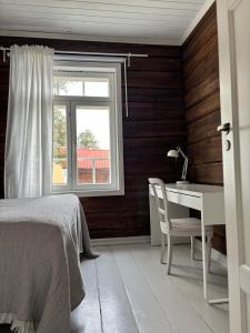 a bedroom with a bed and a desk and a window at Villa Hirsipirtti in Rovaniemi