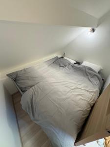 a white bed in a room with a wall at T2 Chez Mongery in Landreville
