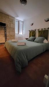 a large bed with two pillows on top of it at Centre Bourg d'Avoine Cottage in Avoine