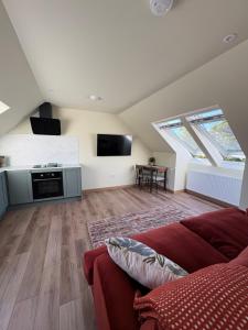 a living room with a couch and a flat screen tv at Coorie-Tigh in Connel