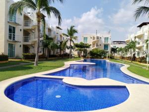 a swimming pool in front of some apartment buildings at Comfortable apartment with pool near beaches in Acapulco