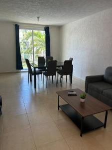 a living room with a couch and a table and chairs at Comfortable apartment with pool near beaches in Acapulco
