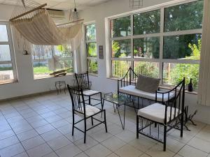 a room with a table and chairs and windows at Cap sur l'Amérique latine in Castelnau-Rivière-Basse