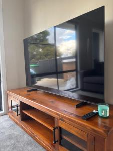 a large flat screen tv sitting on top of a wooden table at Deni's Home in Parkes