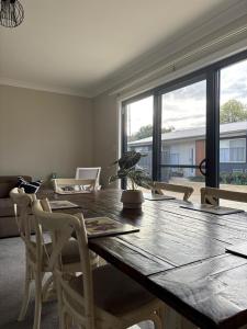 a dining room with a wooden table and chairs at Deni's Home in Parkes