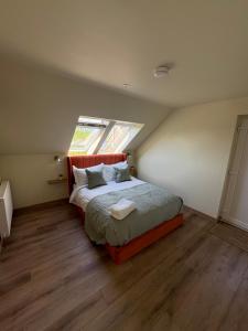 a bedroom with a large bed with a window at Coorie-Tigh in Connel