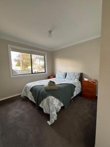 a bedroom with a large bed with a window at Deni's Home in Parkes