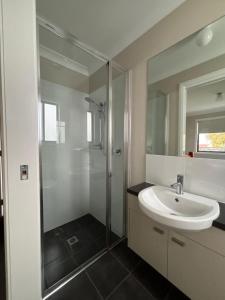 a bathroom with a glass shower and a sink at Deni's Home in Parkes +47 photos