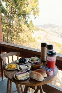 a wooden table with food on top of a balcony at Chalé Theo - Para momentos únicos in Camanducaia +33 photos