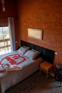 a bedroom with a bed in a brick wall at Chalé Theo - Para momentos únicos in Camanducaia