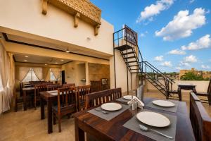 a dining room with tables and chairs and a staircase at Hotel Saffron Diamond in Jaisalmer