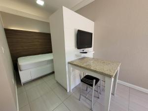 a small room with a table and a bed at MD House Express - Petrópolis in Passo Fundo