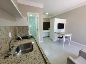 a large bathroom with a sink and a television at MD House Express - Petrópolis in Passo Fundo +1 photo