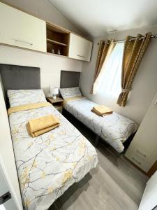 a bedroom with two beds and a window at Lakeside Bliss with Fishing Peg and Hot Tub in Tattershall