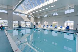 a large swimming pool with blue chairs in a building at Bonita Beach Hotel in Ocean City