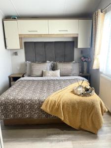 a bedroom with a large bed with a large headboard at Lakeside Bliss with Fishing Peg and Hot Tub in Tattershall