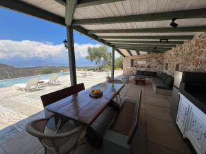 an outdoor dining area with a wooden table and chairs at Olive Guest Farm in Akrata