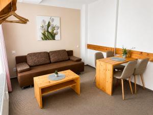 a living room with a couch and a table at Aparthotel Belveder in Tatranská Lomnica