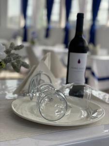 a white plate with a bottle of wine on a table at Residencial FSFA in Praia