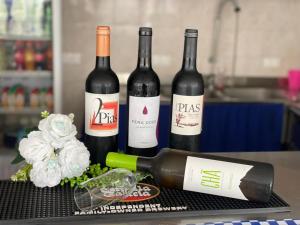 a group of three bottles of wine on a table at Residencial FSFA in Praia +17 photos