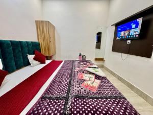 a bedroom with a large bed with a tv on the wall at Hotel Vrinda mohan kunj Near Prem Mandir in Vrindāvan +29 photos