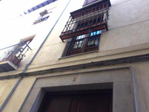 un edificio con dos ventanas y una escalera de incendios en Bonito Apartamento en el centro de Granada con parking gratis, en Granada