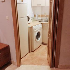 a kitchen with a white refrigerator and a washing machine at Bonito Apartamento en el centro de Granada con parking gratis in Granada
