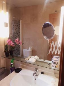 a bathroom with a sink and a mirror at Bonito Apartamento en el centro de Granada con parking gratis in Granada