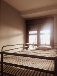 a bed in a room with a window at Bonito Apartamento en el centro de Granada con parking gratis in Granada