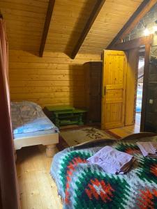 a bedroom with two beds in a log cabin at Ребровач in Tatariv