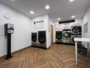 a laundry room with three washer and dryer machines at Hostería La Antigua in Potes