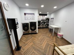 a laundry room with three washer and dryer machines at Hostería La Antigua in Potes