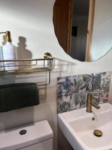 a bathroom with a sink and a mirror at Jacobite Cabin in Inverlochy +5 photos
