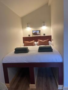 a bedroom with a large bed with two pillows on it at Jacobite Cabin in Inverlochy