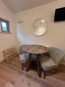 a table and chairs in a room with a mirror at Jacobite Cabin in Inverlochy