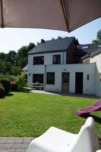 a white house with a yard with a slide at Vakantiewoning Spoor 23 in Borgloon