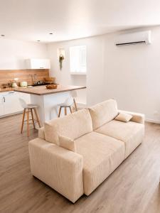 a living room with a couch and a kitchen at L'immeuble du Monde Rose - Appartements neufs climatisés - classés 3 étoiles - Vic le Comte - Auvergne in Vic-le-Comte
