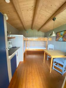 a kitchen with a table and a wooden floor at Fossen Camping Fagernes in Døvre