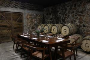 a long table in a room with a bunch of wine barrels at Hotel Casa De Quino in Querétaro