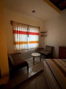 a bedroom with a bed and two chairs and a window at Casa María Bonita - Loft Bonito in La Cal
