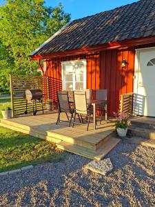 a cabin with chairs and a table on a deck at Fin torparstuga strax utanför Falköping. in Falköping