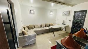 a living room with a couch and a table at Dar Calme Takad in Ben Guemoud