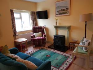a living room with a blue couch and a fireplace at Culoort Cottage - Malin Head in Malin Head