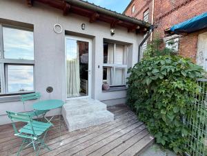 a house with a table and chairs on a deck at Apartamenty Stara Winiarnia in Wałcz