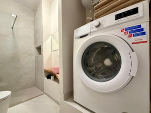 a washing machine in a bathroom with a toilet at Apartamenty Stara Winiarnia in Wałcz