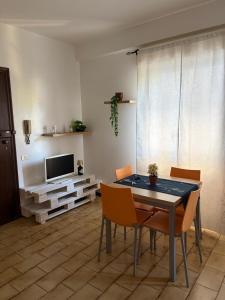 a living room with a table and chairs and a television at Casa vacanza Emily in Pedaso