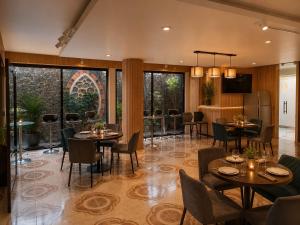 a dining room with tables and chairs and windows at Hotel Galería Mediterráneo in Santa Ana Huiloac
