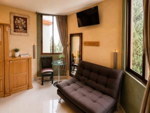 a living room with a couch and a tv at Hotel Galería Mediterráneo in Santa Ana Huiloac